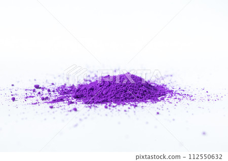 a bunch of dry natural purple pigment on a white background macro 112550632