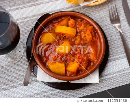 Traditional Spanish dish of potatoes simmered with chorizo, pancetta, vegetables 112551486