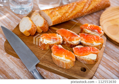 Appetizer canape of baguette with smoked salmon 112551630