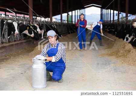 Adult male farmer with can works on dairy farm 112551691
