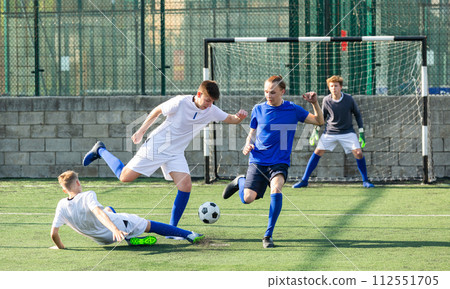 Youthful football players challenging for ball Youthful football players challenging for ball 112551705