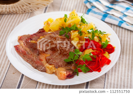 Veal steak with fried potato and pepper 112551750