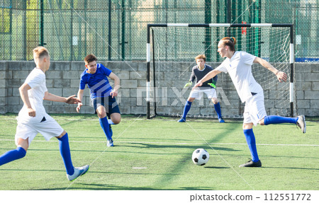 Teens playing soccer football match. Competition between two youth soccer teams Teens playing soccer football match. Competition between two youth soccer teams 112551772