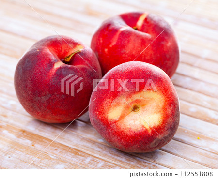 Closeup of whole ripe red peaches on wooden table. Closeup of whole ripe red peaches on wooden table. 112551808