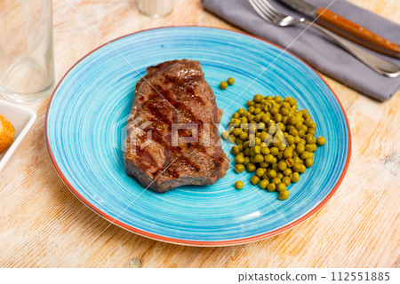 Roasted beef with green peas served on table Roasted beef with green peas served on table 112551885