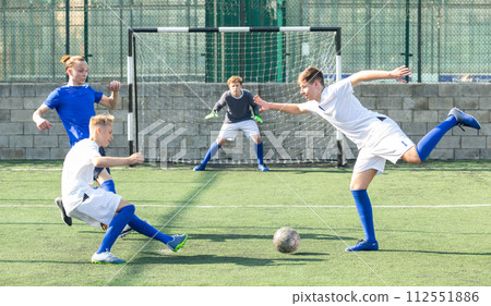 Game of football match between two teams of teenagers in white and blue shirts 112551886