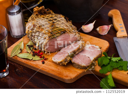Boiled pork on chopping board with mixed peppercorns, bay leaf, cinnamon 112552019
