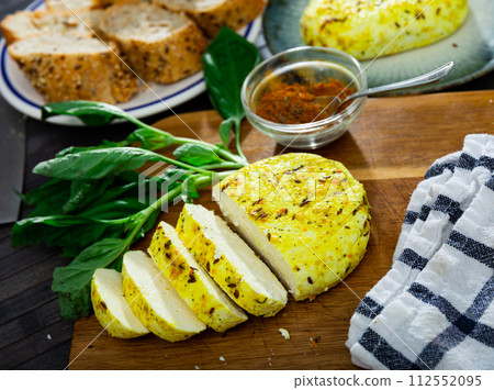 Pieces of hard yellow lithuanian cheese with dried caraway with herbs on the kitchen board Pieces of hard yellow lithuanian cheese with dried caraway with herbs on the kitchen board 112552095