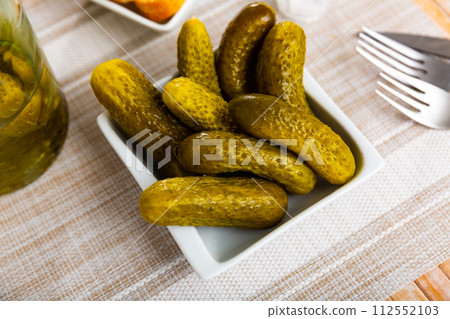Pickled cucumbers on white plate, homemade preserves Pickled cucumbers on white plate, homemade preserves 112552103