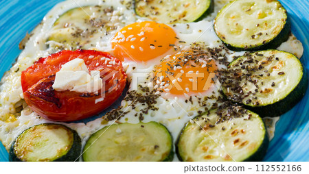 Fried eggs with zucchini and tomatoes Fried eggs with zucchini and tomatoes 112552166