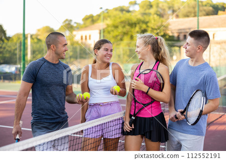 Four smiling sportsmens men and women with rackets emotionally talking and laughing 112552191