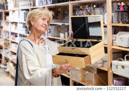 Woman choosing jewelry storage box at store 112552227