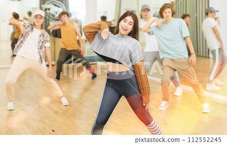 Cheerful hispanic teenage girl practicing hip-hop movements in studio 112552245