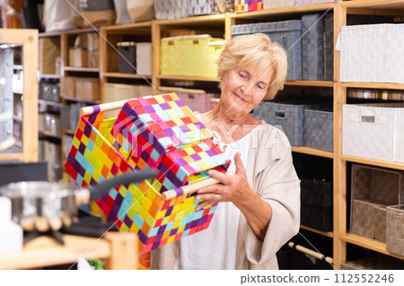 Elderly positive woman choices bathroom boxes at hardware store Elderly positive woman choices bathroom boxes at hardware store 112552246