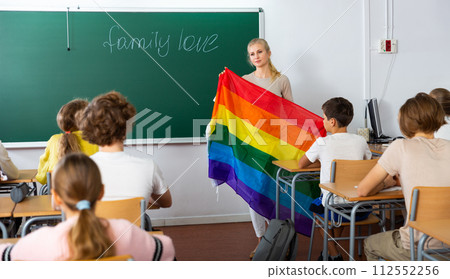 Teacher explaining LGBT flag meaning for kids during lesson Teacher explaining LGBT flag meaning for kids during lesson 112552256