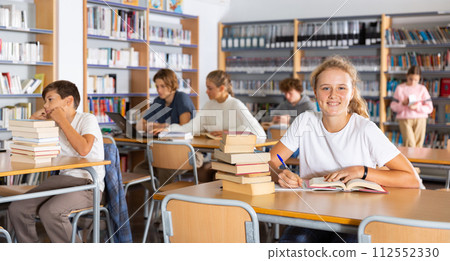 Teenage boys and girls in library Teenage boys and girls in library 112552330