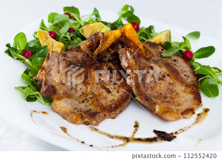 Pork chop, salad with avocado and berries 112552420