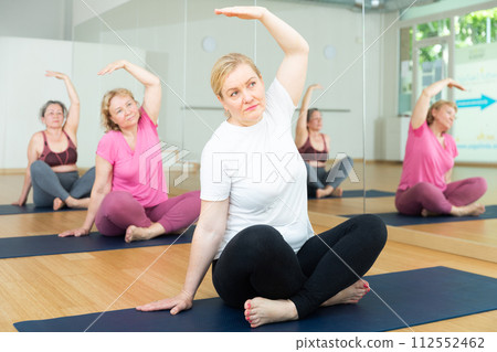 Active senior woman practicing yoga at group 112552462