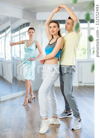 Positive man and woman practicing samba in dance class Positive man and woman practicing samba in dance class 112552493