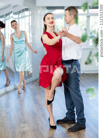 Couple in stage costumes learns boogie woogie dancing during individual lesson Couple in stage costumes learns boogie woogie dancing during individual lesson 112552500