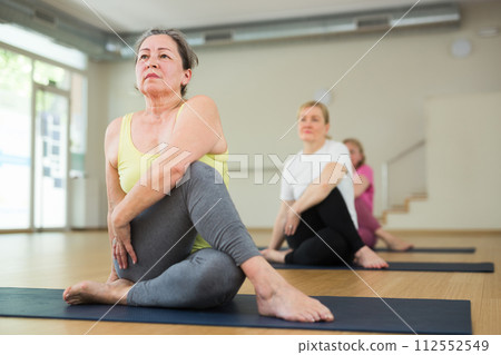 Active elderly woman practicing yoga at group Active elderly woman practicing yoga at group 112552549