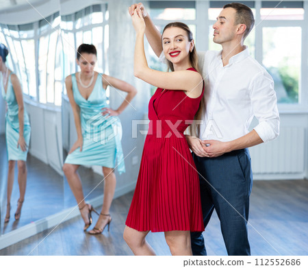 Couple in stage costumes learns boogie woogie dancing during individual lesson Couple in stage costumes learns boogie woogie dancing during individual lesson 112552686