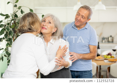 After chatting and gatherings, two mature women friends hug and kiss goodbye. After chatting and gatherings, two mature women friends hug and kiss goodbye. 112552728