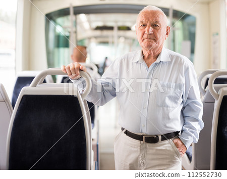 Elderly man standing in tram Elderly man standing in tram 112552730
