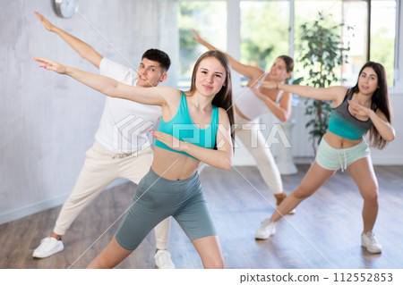 Girl teen perform choreographic exercise and teach energetic mobile social dance vogue with friends 112552853