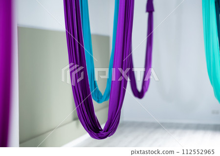 Suspended hammocks for aerial or anti-gravity yoga in empty fitness studio 112552965