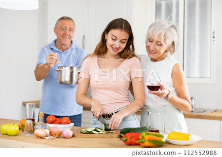 Happy family of three preparing lunch together in modern kitchen 112552988