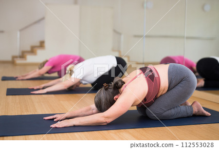 Active senior woman practicing yoga at group Active senior woman practicing yoga at group 112553028