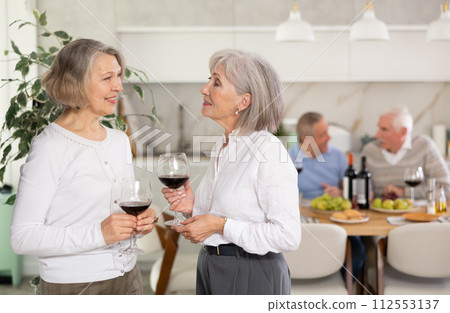 Mature women sharing news and gossip during holiday dinner at home Mature women sharing news and gossip during holiday dinner at home 112553137