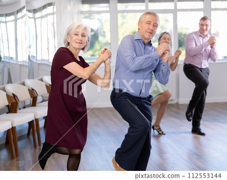 Senior man and elderly woman are dancing contemporary twist in couple Senior man and elderly woman are dancing contemporary twist in couple 112553144