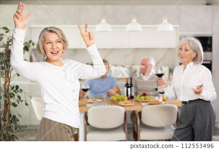 Senior men and women have fun dancing during house party. Senior men and women have fun dancing during house party. 112553496