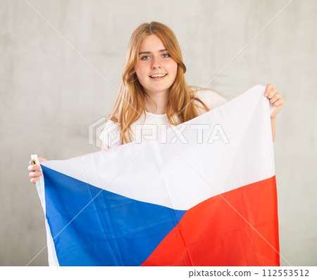 smiling girl in arms raised above head holds cloth of national flag of Czechia 112553512
