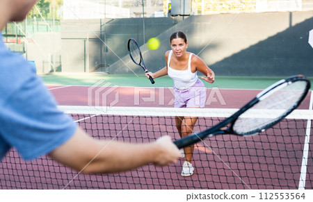 Young woman playing tennis on court Young woman playing tennis on court 112553564