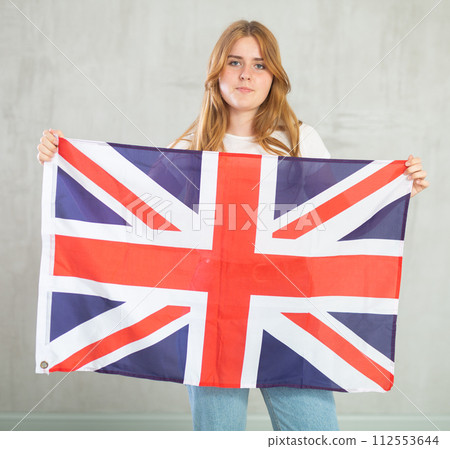 Calm girl holds canvas of national British flag 112553644