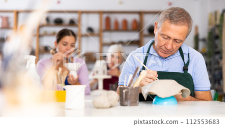 elderly potter is working with clay billet elderly potter is working with clay billet 112553683
