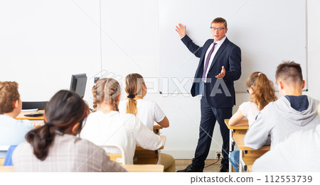 Male teacher lecturing to students at classroom 112553739
