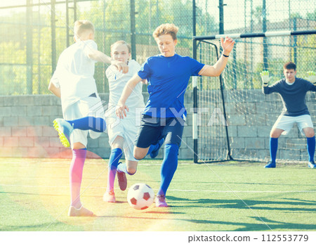Teens playing soccer football match. Competition between two youth soccer teams Teens playing soccer football match. Competition between two youth soccer teams 112553779