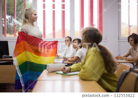 Teacher explaining LGBT flag meaning for kids during lesson Teacher explaining LGBT flag meaning for kids during lesson 112553822