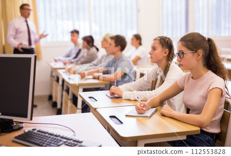 Teenage students studying in classroom with teacher Teenage students studying in classroom with teacher 112553828