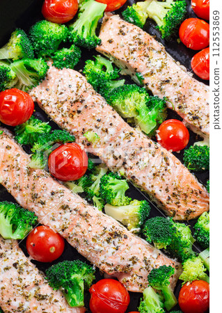 One pan dish baked salmon fillet with broccoli and tomato, vertical, top view, closeup One pan dish baked salmon fillet with broccoli and tomato, vertical, top view, closeup 112553869