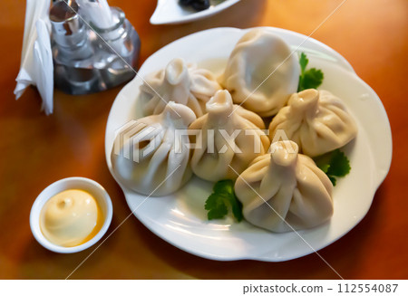 Khinkali, Georgian dumplings with sauce and parsley Khinkali, Georgian dumplings with sauce and parsley 112554087