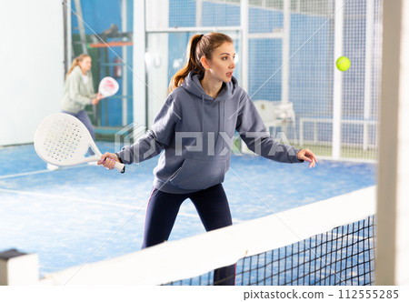Woman playing padel tennis on padel court 112555285