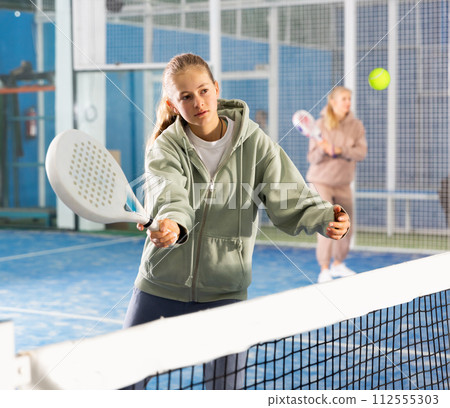 Girl tennis player playing padel tennis Girl tennis player playing padel tennis 112555303