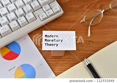 Desk with a card that says Modern Monetary Theory Desk with a card that says Modern Monetary Theory 112555849
