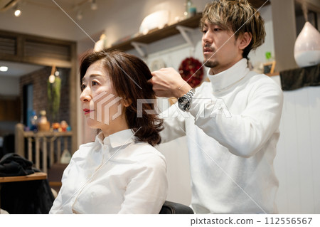 A woman getting her hair done at a beauty salon 112556567