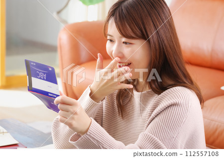 一個女人看著她的銀行存摺時看起來很高興 112557108